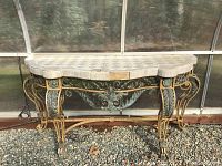 Front view showing curved tiled top and ornate metal scrollwork base