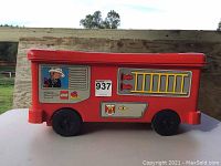 Front and side view of the red ride-on fire engine with firefighter decals and wheels