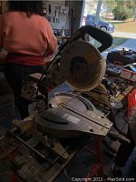 Front view of miter saw mounted on work stand showing handle, blade guard and base