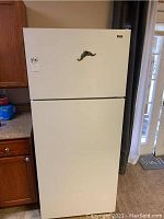 Front view of white HotPoint refrigerator with top freezer and white handle.