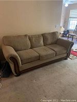 Front angle view of brown Knapp sofa with three cushions and wooden base detailing