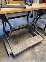 Workbench with wooden top and metal frame, showing the Black & Decker Workmate logo on the horizontal support bar.