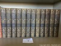 Front view of all twelve volumes lined up on shelf showing gilt-decorated spines and volume numbering