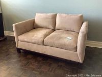 Front-right angled view of loveseat showing overall shape and condition