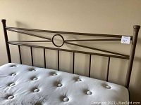 Full view of metal headboard attached behind mattress