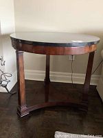 Full front view of round table showing marble top and wooden base