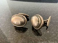Pair of cufflinks front view on dark granite