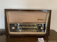 Front view showing the wood cabinet, speaker grille, tuning dials, and push buttons of the vintage Rigolusso Norseman HiFi radio.