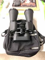 Front angled view of Tasco Zip binoculars sitting on top of the Tasco carry bag displaying textured grips and large objective lenses.