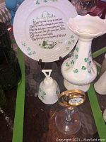 Photo showing Irish Blessing ceramic plate with shamrocks, tall ceramic vase with shamrocks and bell, and Killarney glass vase clock.