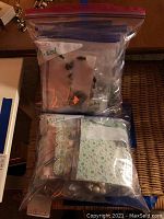 Two large Ziploc bags labeled 'mixed' containing multiple small plastic bags with assorted costume jewelry inside.