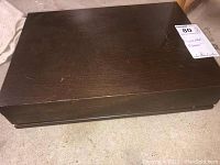 Closed dark wooden box containing flatware set