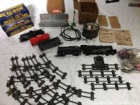 Train set components overview showing various train cars, track, transformer, bridge, street light, and original boxes.