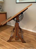 Side angle showing oak top tilted and cast iron gear mechanism