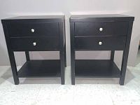 Front view of two identical black end tables side by side showing two drawers and bottom shelf each.