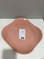 Top-down view of the coral-colored square chop platter showing smooth rounded corners and some signs of crazing on surface.