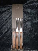 Full set of vintage Cutco carving utensils with wall mount storage tray on black fabric background