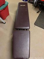 Overhead view of weight bench in flat position showing length and vinyl cushion condition.