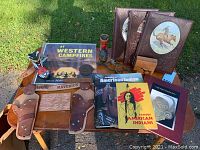 Overview image showing all Wild West collectibles including metal spurs, leather holsters, miniature boots, books, horse figurines, and a vinyl record album.