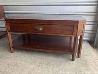 Full view of the mission style coffee table showing the drawer front, bottom shelf, legs, and cut corner top design in a dark finish.