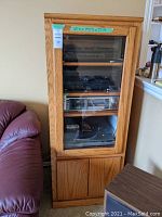 Front view of the solid wood cabinet showing glass door with shelves inside and wooden doors at bottom
