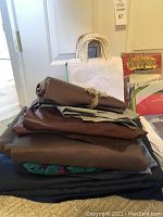 Stack of dark and brown craft papers and multiple gift bags with handles