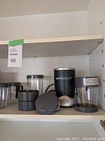 Photo showing two blender units and multiple clear plastic containers with lids stacked and arranged on shelf.