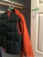 Reversible men's vest showing quilted green canvas front and orange lining inside