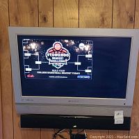 32-inch Element HDTV on tabletop stand with Polk soundbar positioned below the TV screen showing a Dish Network bracket challenge display.