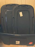 Two navy blue 49 gallon storage totes with lids inside one tote, showing the size and shape.