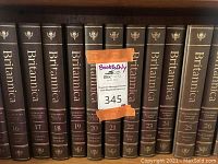 Photo of Encyclopaedia Britannica volumes 16 to 26, black hardcovers with gold embossed titles focusing on various topics such as Education Evolution, Greek Economy, Italian Life, Greek Metabolism, and more.