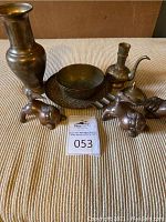 Full lot including vase, two Foo Dogs, bowl, tray, pot, and cigar ashtray on striped fabric background.