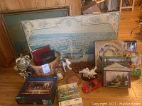 Image showing entire lot of decorative items including framed pictures, puzzles, ceramic dog, basket, photo album and small figurines.