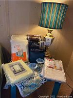 Overview of new curtain panels in original packaging displayed on blue small table, with brass lamp and candle holders