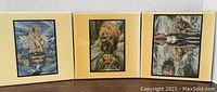 Photo of three art tiles arranged side by side showing different bear and Native American themes with beige framing.