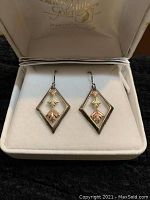 Pair of Black Hills Gold earrings displayed in a jewelry box, showing diamond shape and tri-color leaf design