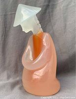 Left side profile of figurine showing peach opalescent body and frosted head