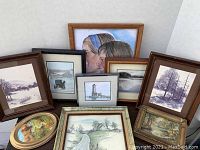 Overview image showing all nine framed pictures arranged together, including the two small oil paintings in front and larger prints behind, various rural and nature scenes.