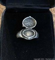 Front view of open poison ring showing interior compartment with textured detail.