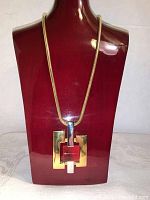 Front view of the Lanvin necklace showing the gold-tone snake chain and the large geometric pendant in gold-tone metal.