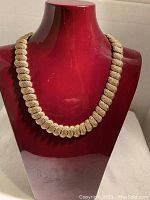 Front view of the gold-tone twisted rope link choker necklace displayed on a red bust.