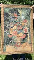 Full view of floral tapestry hanging outdoors showing detailed floral bouquet and decorative border.