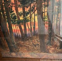 Watercolor painting depicting a deer in forest with sunset, framed in Mission oak with glass, showing full painting and frame.