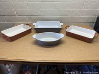 Front view of 4 ceramic serving dishes on table showing varied shapes and colors