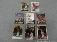Top down view of eight Michael Jordan sports cards arranged on grey surface