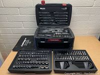 Overview of main tool case open on table with top tray removed showing bottom sockets and driver tools