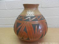 Front view of large vintage Mata Ortiz pottery vase showing geometric pattern and narrow neck with dotted texture.