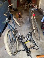 Wide view showing two bicycles (men's blue and women's gray) and a black bike rack on ground