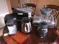 Overview of all five kitchen appliances on a round wooden table.