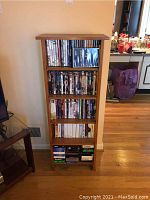 Front view showing DVDs on multiple shelves within the wooden media stand.